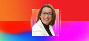 Smiling business leader wearing glasses against a colourful gradient background