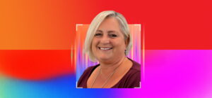 Smiling woman with short blonde hair against a vibrant red, pink and blue gradient background.